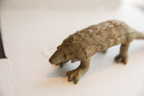 The textured, scaled body and pointed snout of the vintage pangolin sculpture.