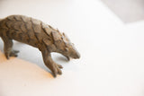 Close-up view of the vintage pangolin sculpture's head and textured, scaly body.