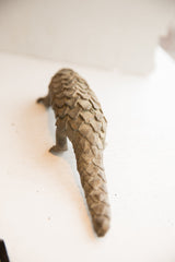 Rear view of the vintage pangolin sculpture highlighting its long, scaled tail.