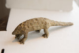 Vintage pangolin sculpture in profile, highlighting its earthy finish and hand-molded scaly texture.