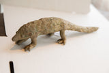 Vintage pangolin sculpture in profile, with textured handmade scales and an earthy, aged finish.
