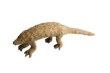Vintage African pangolin sculpture featuring a sandy, textured body with overlapping geometric scales.