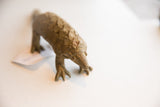 Detailed view of the pangolin sculpture's hand-carved head and earthy, textured scales.