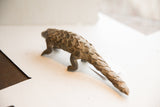 Textured overlapping scales on the back and tail of the vintage pangolin sculpture.