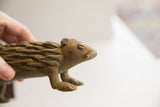 Vintage porcupine sculpture held to show scale and the handmade texture of its quills.