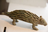 Side profile of a vintage porcupine sculpture with a textured, patinated surface.