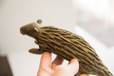 A hand holding the vintage African porcupine sculpture, showing its textured profile.