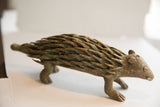 Side profile of the vintage African porcupine sculpture showing its textured aged finish.