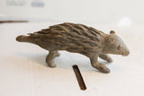 Side profile of the handmade porcupine sculpture showing its textured, earthy finish.