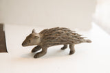 Profile view of the vintage porcupine sculpture showing its rustic, handmade texture.