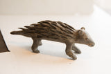 Side view of a vintage African porcupine sculpture with textured, hand-carved quills.