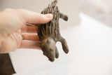 Vintage handmade African porcupine sculpture held in hand, revealing its scale and texture.