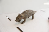 The aged patina and hand-carved texture of a vintage porcupine sculpture.