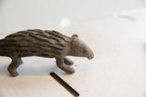 Side view detailing the carved face and textured quills of the handmade African porcupine.
