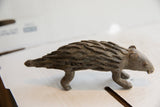Vintage African porcupine sculpture shown in profile with a coarse, dark handmade texture.