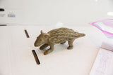 Side profile of a vintage African porcupine sculpture showing its hand-carved texture.