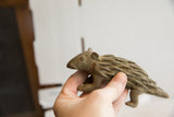 Vintage African porcupine sculpture held in hand, showing its textured profile and scale.