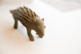 Expressive face with handmade details on a vintage African porcupine sculpture.