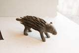 Side profile of a handmade African porcupine showing its rustic, textured body.