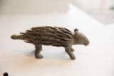 Full side view of the textured, handmade vintage African porcupine sculpture.