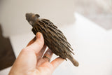 Side view of a vintage African porcupine sculpture showing its scale and hand-carved texture.