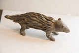 Vintage African porcupine sculpture in profile, showing its rough, hand-carved surface.
