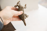 Vintage African porcupine sculpture held in hand, revealing its textured back and rustic finish.
