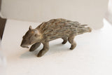 The textured quills and aged, patinated surface of the handmade African porcupine sculpture.