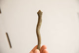 The handmade charm and patinated texture on a vintage African snake figurine.