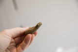 Side profile of the vintage African snake figurine showing its rustic form.