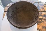 Dark, hand-carved interior of the antique African wooden bowl revealing aged patina and visible cracks.