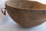 Incised geometric patterns and aged texture on an antique African carved wooden bowl.