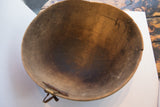 Aged interior of the antique African carved wooden bowl, with visible leather repair and cracks.