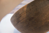 Hand-carved incised patterns and aged wood texture of the African bowl.