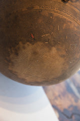 Rich brown texture of the antique wooden bowl with incised patterns and visible cracks.