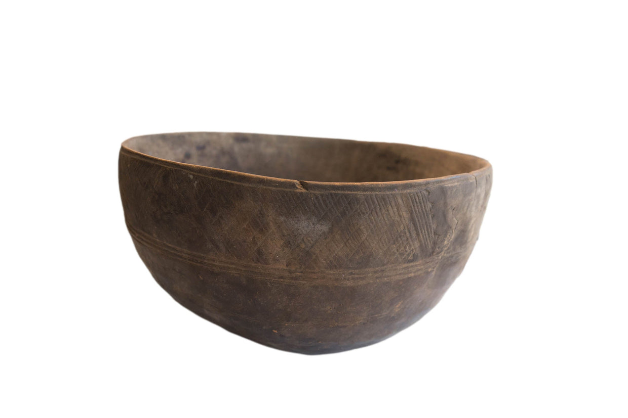 Antique African hand carved wooden bowl, incised designs, visible repairs, and deep patina.
