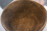 Aged interior surface of a hand carved African wooden bowl with deep cracks.