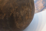 Rich dark brown patina and rugged texture of the antique African bowl's surface.