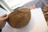 Hand-carved African wooden bowl displaying incised geometric patterns and aged repairs.