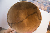 Visible stitched repair on the interior of the antique African carved wooden bowl.