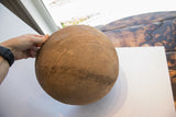 Hand holds antique African wooden bowl, highlighting incised geometric patterns and aged wood texture.