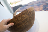 Antique African wooden bowl exterior, displaying old repairs and deep wood grain.
