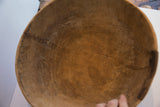 Aged interior of the carved wooden bowl, displaying visible cracks and old repairs.