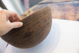 Hand holding antique African hand carved bowl, revealing incised geometric pattern.