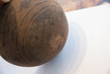 Aged dark wood of the antique African bowl, featuring incised lines and a visible crack.