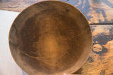Aged dark brown interior of antique Nupe hand carved wooden bowl, showing cracks and incised design.