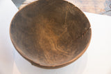 Close-up of the antique wooden bowl's interior, showing aged cracks and a rich, worn patina.