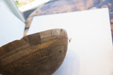 African hand carved bowl showing dark wood, incised linear patterns, and patched repairs.