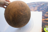 Antique African wooden bowl's dark brown wood grain with incised patterns and age cracks.