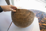 Incised geometric patterns and significant age cracks on the carved African bowl.